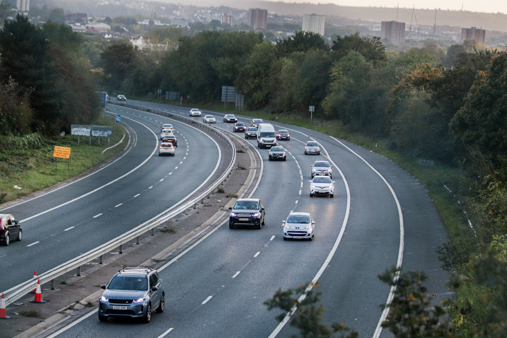 Traffic on a UK motorway at dusk — the kind of drive where a podcast keeps you company